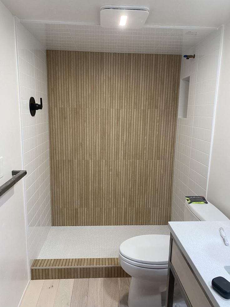 Bathroom wall featuring cream fluted tiles creating dynamic light and shadow effects.