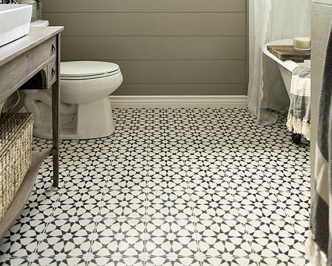 Bathroom floor featuring black star-and-cross patterned handmade tiles for artisanal appeal.