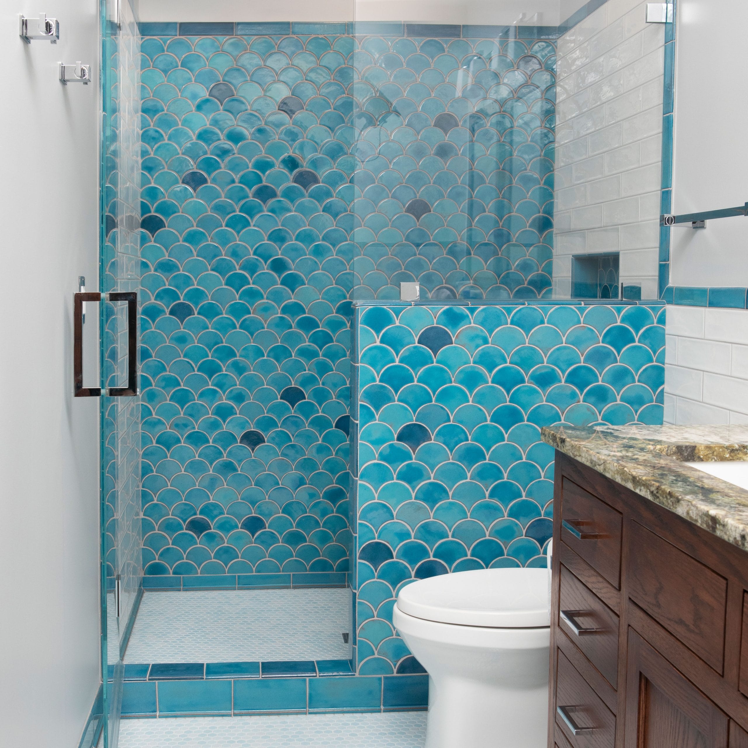 Bathroom wall featuring blue scalloped tiles arranged in a soothing wave pattern.