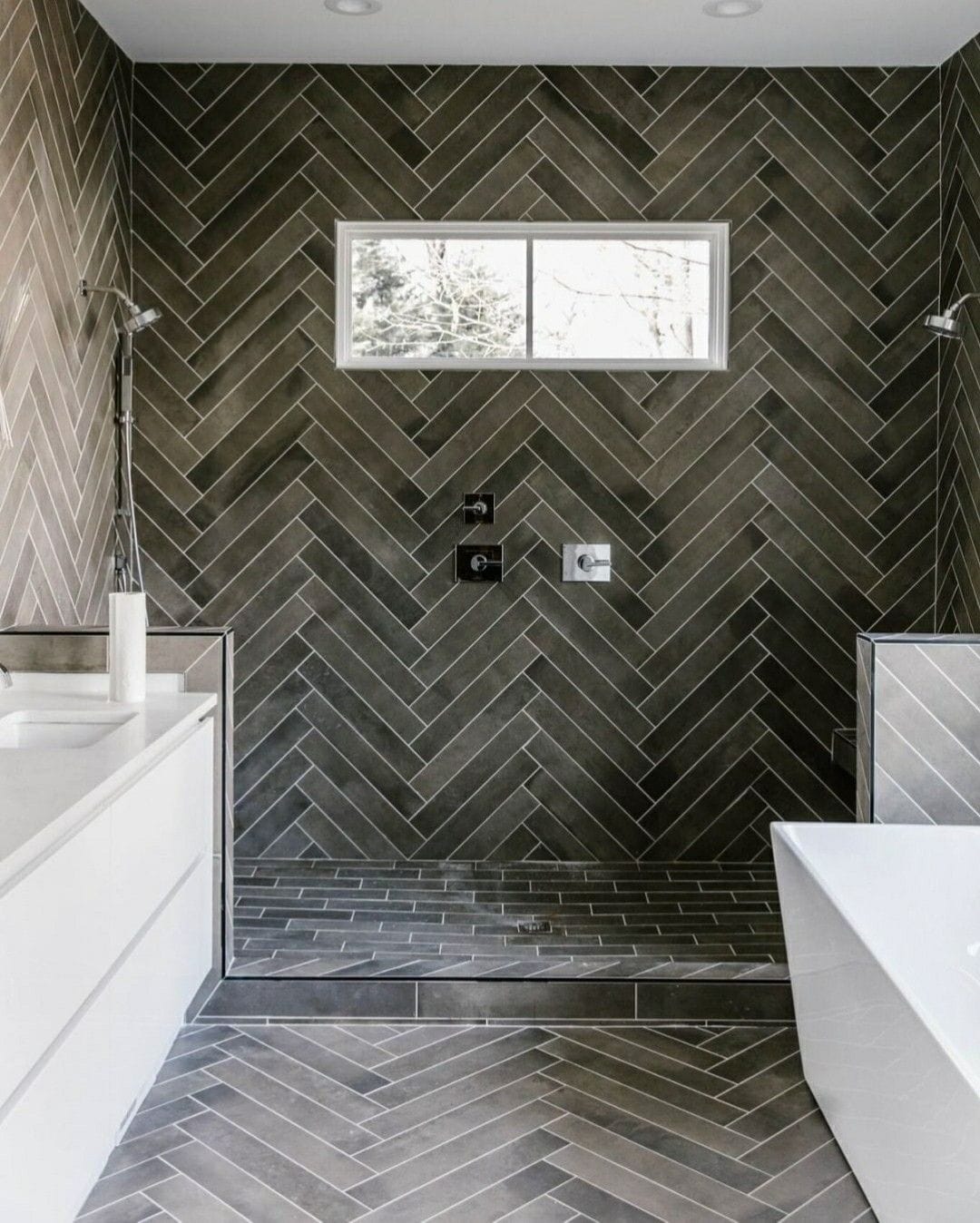 Bathroom featuring handmade-look tiles in a herringbone pattern for a modern neutral look.