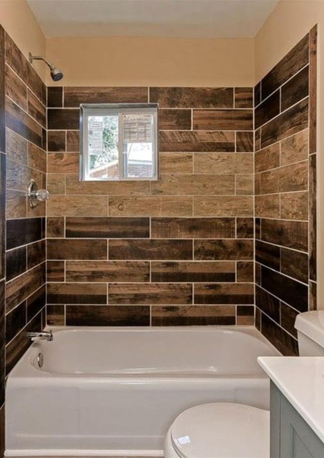 Bathroom featuring wood-look wall tiles and neutral stone-look floor tiles creating a serene spa-like ambiance.