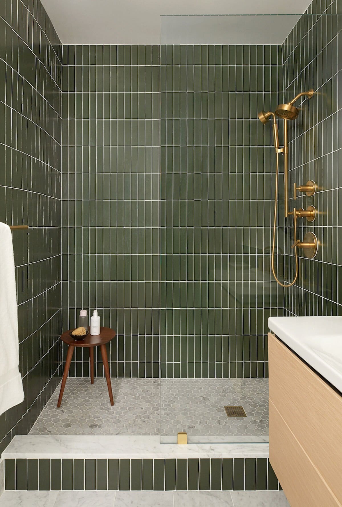 Bathroom wall featuring vertically stacked slim white tiles enhancing the sense of height.