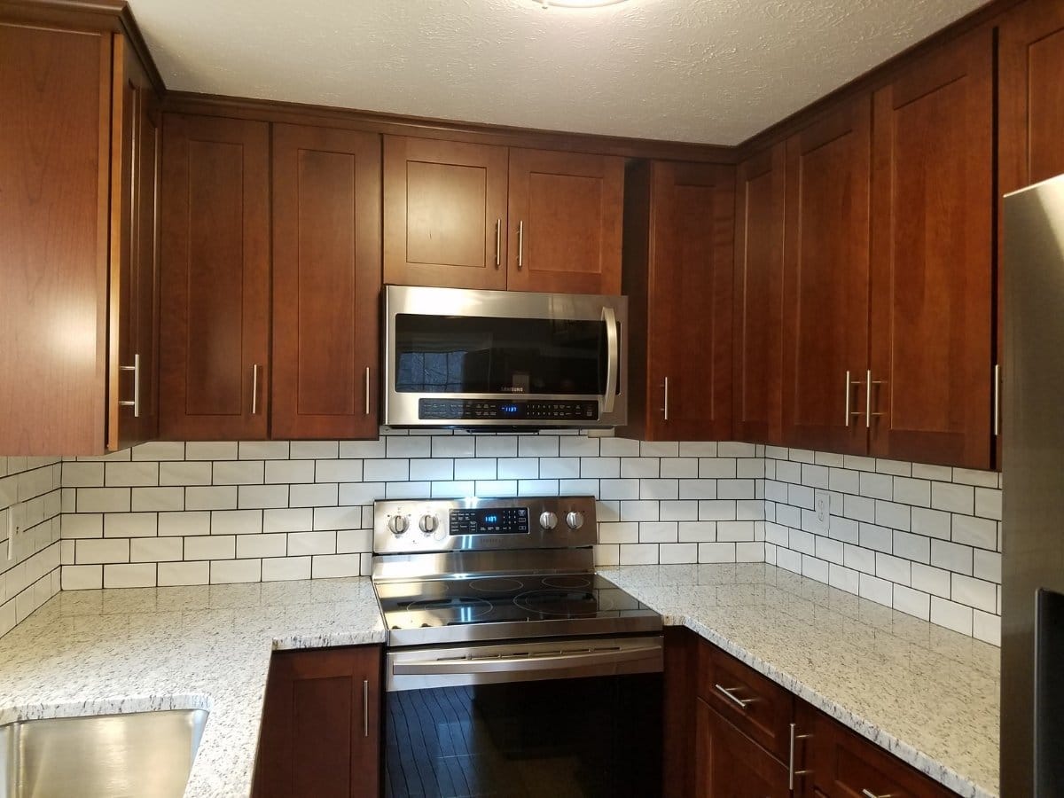 White subway backsplash with dark grout by SAVU LLC