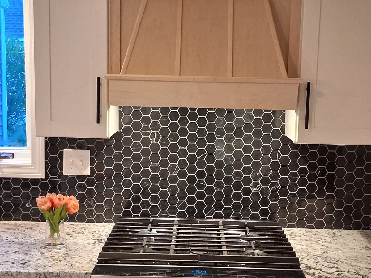 Black marble tile backsplash in honeycomb pattern and white grout