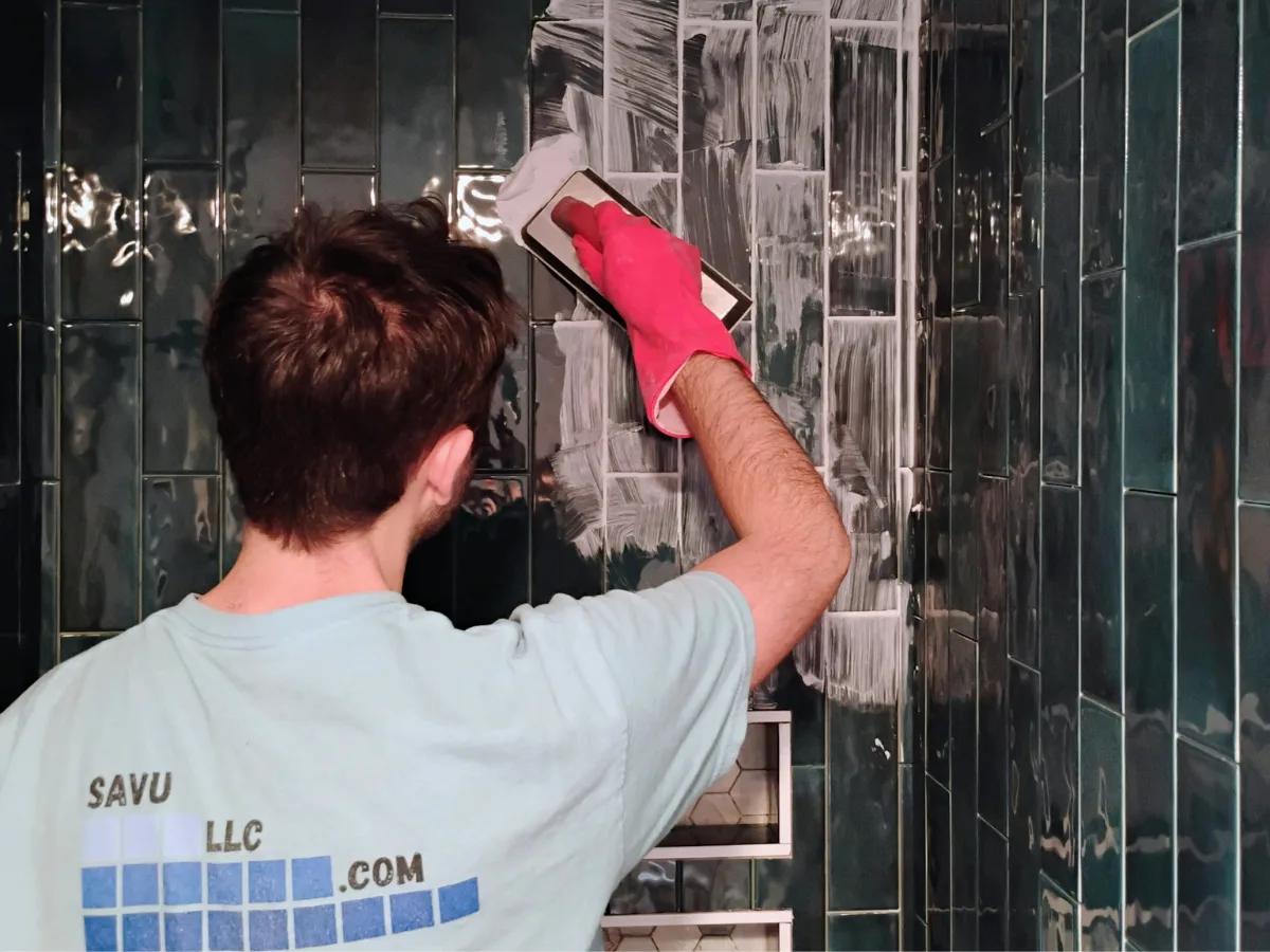 Grouting dark green subway tile shower walls in vertical layout