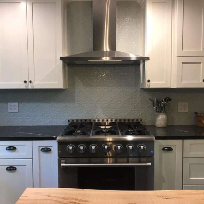 Arabesque Ceramic Tile Backsplash Large arabesque ceramic tile backsplash in a white kitchen with classic design elements.