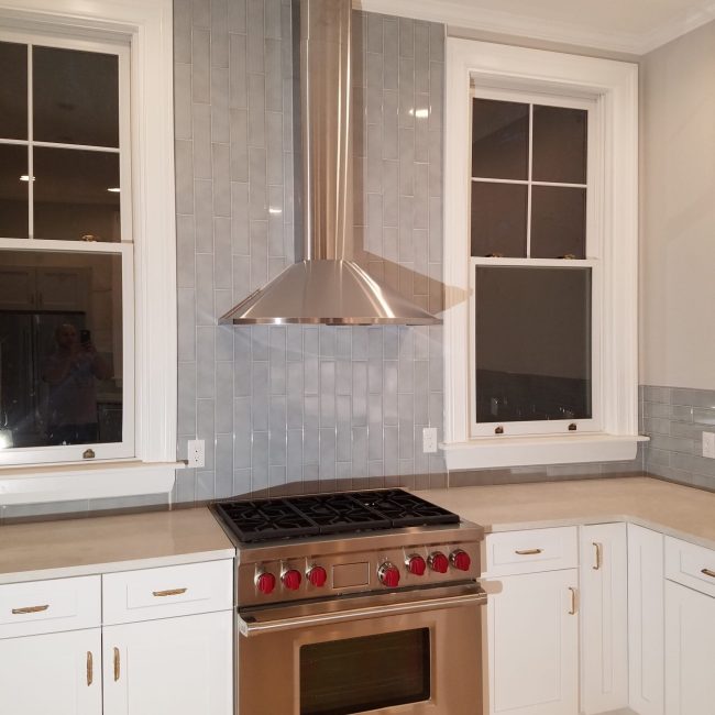 Vertical Gray Ceramic Subway Tile Backsplash Vertical gray ceramic subway tile backsplash in a modern kitchen