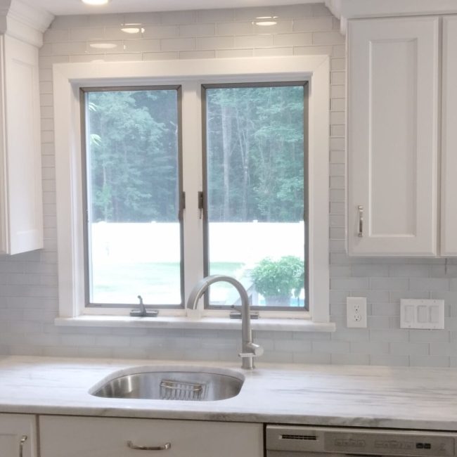 Sleek Glass Tile Backsplash for a Bright, Airy Kitchen Ceiling-high glass tile backsplash in a modern kitchen with white cabinets and reflective surfaces