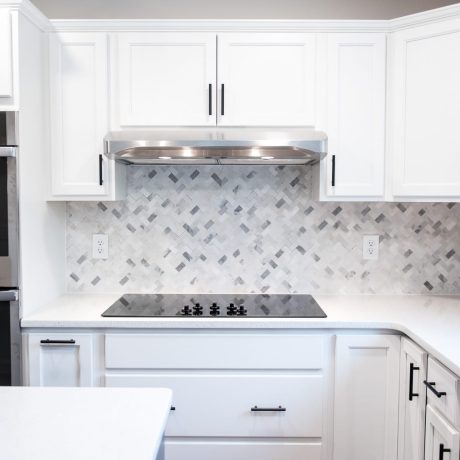 White and gray marble herringbone tile backsplash